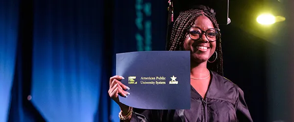 APUS graduate smiling with diploma